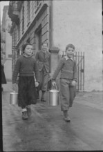 Children bringing home soup from public kitchen; 1945.