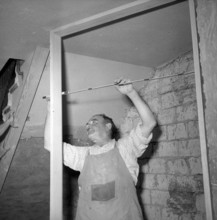 Carpenter at building site; 1953.