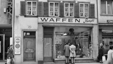 Arms shop; men watching in the shop window 1969.