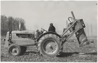 A machine tractor equipped with a special hydraulic tool to remove stumps from the ground