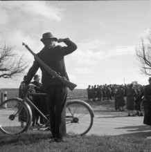 Civilian marksman with bicycle looking at female soldiers, Weinfelden 1954.