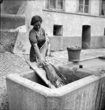 Fribourg; laundress at St. Anne fountain; 1945.