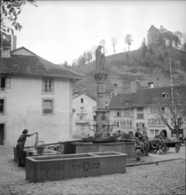 Fribourg; laundress at St. Anne fountain; 1945.