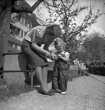 Mother and daughter playing outdoors, Switzerland 1940.