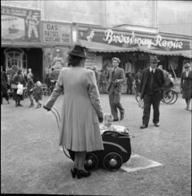 Woman strolling with a pram; 1942.