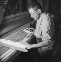 Man weaving a carpet, 1940.