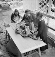 Women with selfmade rag rug, 1940.