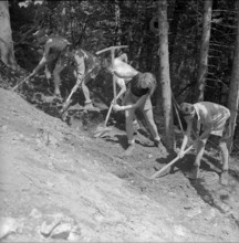 Isenfluh, volunteers building access road to mountain village; 1959.
