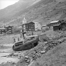 Clearance work after flood in the valais village Tasch; 1957.