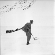 Avalanche at Weissfluhjoch, men searching for missed persons, avalanche victim; 1956.
