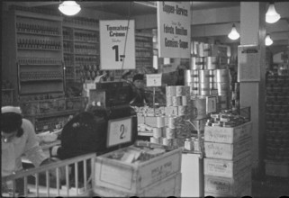 Salesperson in a food shop; soup on offer; 1945.