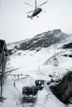 Helicopter transporting cable car cabin.