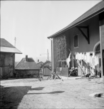 Little boy sitting in front of a house in Longirod VD, 1945.