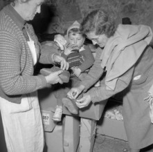 Hungarian women clothing a child, Uerikon 1956.