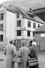 Women in front of burned out ski factory in Glarus 1969.