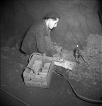 Herznach mine, miner prepares for blasting; 1952.
