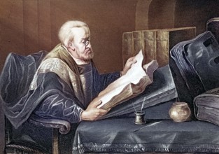 scholar with a book at a desk. reading. Elderly man reading a book with concentration. quiet study