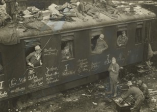 Soldiers on trains passing through Bolzano station.