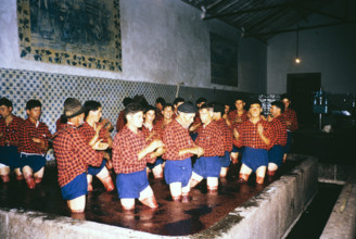 A series of images about port wine production in Portugal c 1960 - men in uniform of shorts and