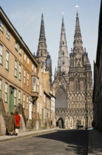 People walking in The Close towards Lichfield cathedral church, Lichfield, Staffordshire, England,