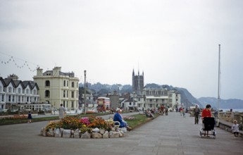Flowers and lawn gardens, people walking on promenade, Teignmouth, Devon, England, UK early 1960s.