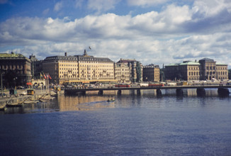 Buses crossing Strombron bridge in city centre with Grand Hotel and National Museum buildings