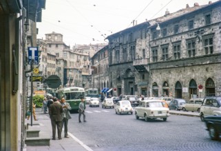 Traffic and tram cars of busy city street in Perugia, Umbria, Italy 1969.