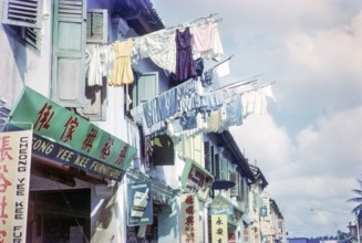 Laundry held out on poles to dry above Chinese shops in  Singapore, south east Asia, 1965.