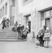 Peseux, nosy children looking through the window to elder pupils attending a cookery course, 1958