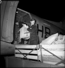 Postbags destined for foreign country (Holland) are loaded in a plane, 1953