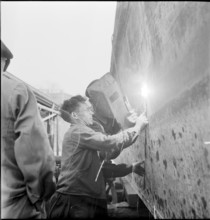 Preparation of overland ship transpor, cutting hull in two with blowtorch, 1946