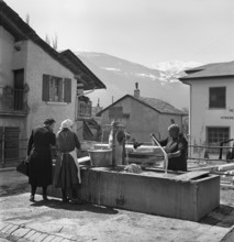 Sierre, women doing their laundry at the fountain, 1941