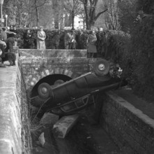 Onlookers watching car recovery out of a stream in Lausanne 1955