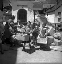 Children carrying parcels, relief supplies for the population of the completely burned down hamlet