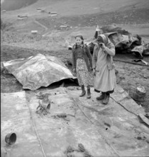 Selva completely burned down, woman and girl watching the remains of their household 1949