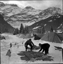 14th Swiss New Year's tent camp in Les Diablerets 1957: men putting a tent up