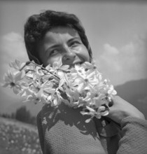 Woman posing with wild narcissus in Vevey, 1942
