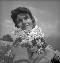 Woman posing with wild narcissus in Vevey, 1942