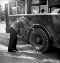 Bus driver checking chains for tyre protection, Berne 1945