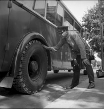 Bus driver checking chains for tyre protection, Berne 1945
