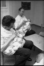 Men feeding babies, 1969