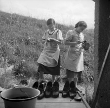 Cleaning shoes at school for household in Casoja, 1940