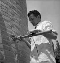 Explosive charge attachment before factory chimney blasting in Geneva 1943