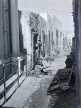 Workers with metal pots in narrow alleyway street in old town medina.