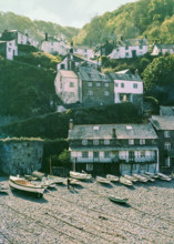 Historic buildings in harbour boats on beach at Clovelly.