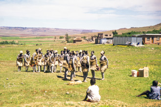 Basotho women dancers in traditional attire practice a performance in a rural area.
