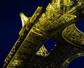 FRANCE, Ile de France, Paris, Eiffel Tower.  Angled view from below floodlit at night.