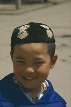 CHINA, Gansu, Lanzhou, Moslem boy wearing velvet beaded cap