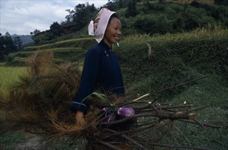 10000593 CHINA Guizhou Leishan Woman carying branches and vegetation and aubergines.