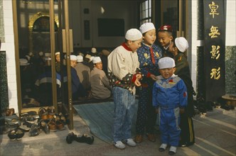 CHINA, Gansu, Lanzhou, Group of muslim boys outside mosque.